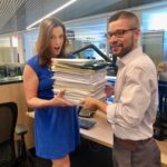Jack Moore & Megan Cloherty holding the documents required to create their podcast in 2019.
